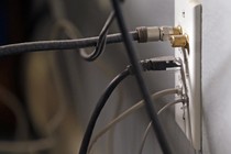 Internet and TV cables plugged into a wall
