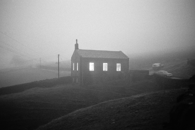 A photo of a building in the middle of a foggy field