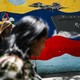 People walk past a mural of a Venezuelan warship and warplane in Caracas.