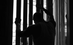 prisoner holding onto bars