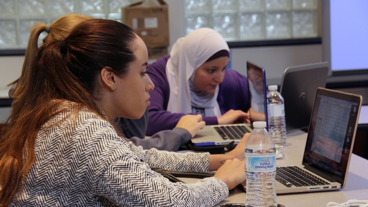 Students sit at laptop computers