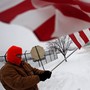 Two days before Christmas of 2008, a resident of Janesville waves a flag outside of the General Motors assembly plant in solidarity with the laid-off workers leaving the plant on its final day in operation.