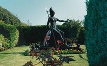 A statue of Britannia in a formal garden