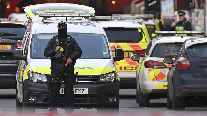 An armed police officer stands in front of a police car in the London Bridge area of the British capital.