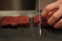 A knife chops a line or raw beef.