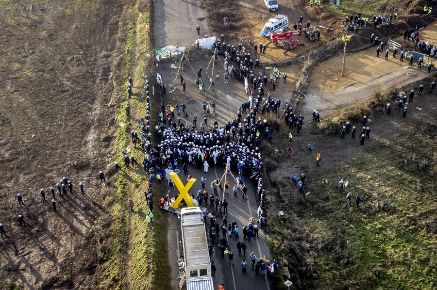 An aerial view of riot police meeting with protesters on a rural road