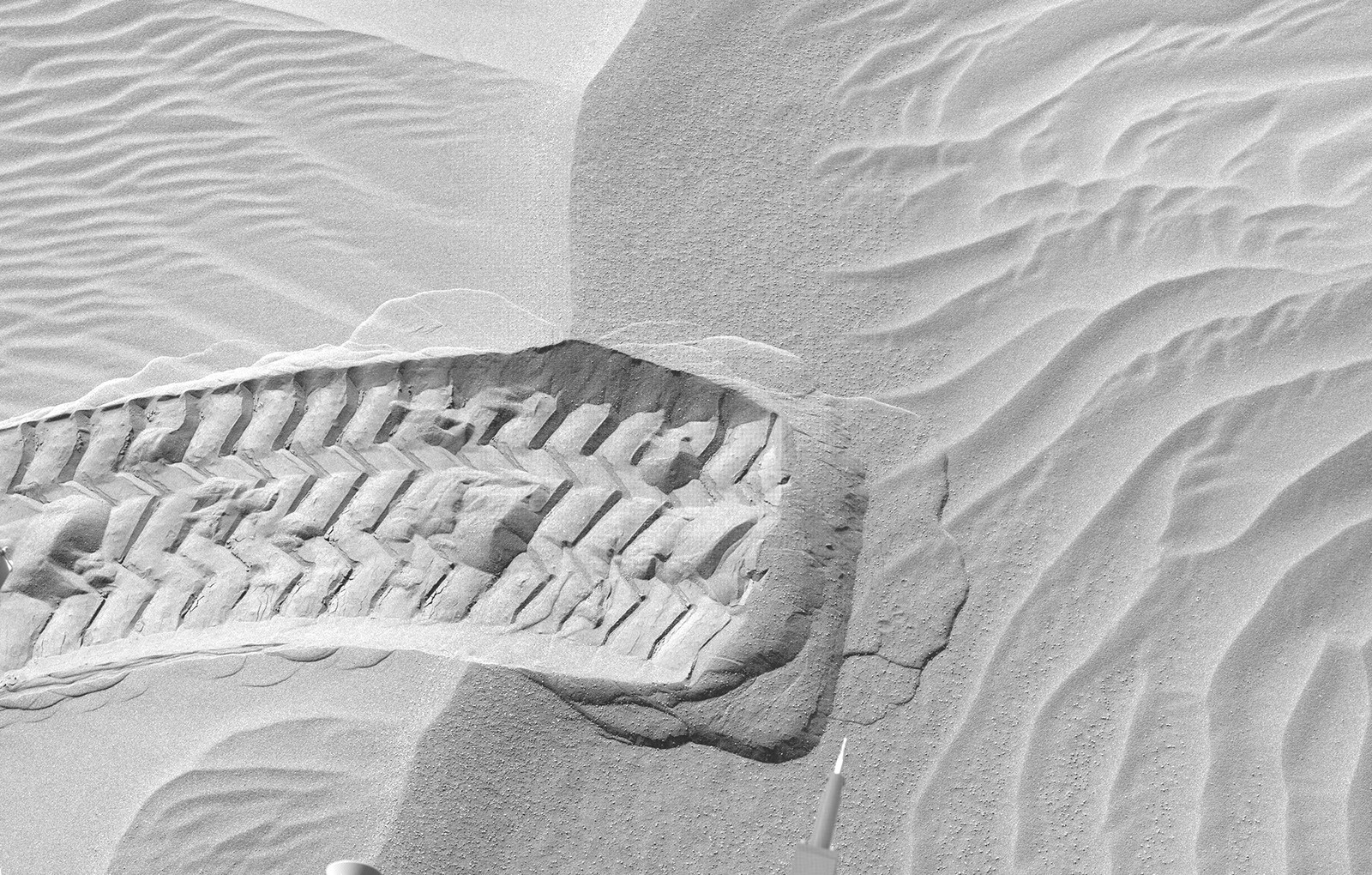 A wheel track in a sandy spot