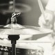 A black and white photo of a senior person playing the drums