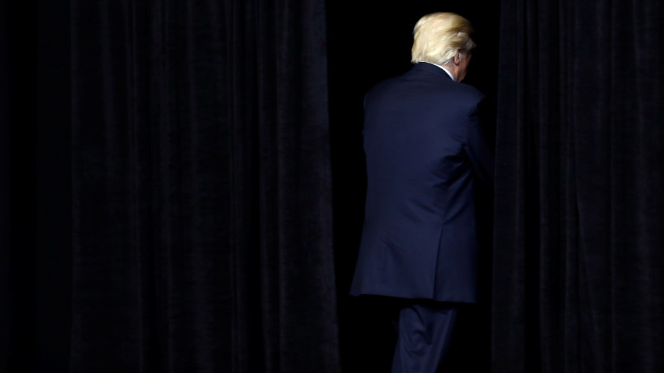 Donald Trump exits a dark stage.