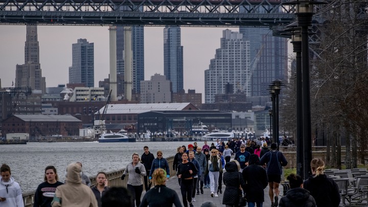 People run through crowds on the East River during the Coronavirus outbreak in New York City.