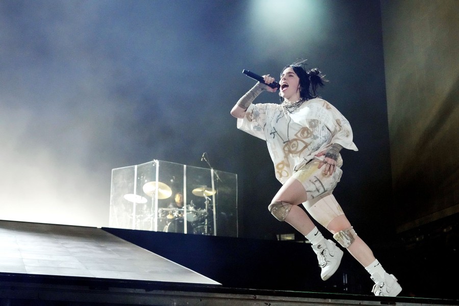Performer Billie Eilish runs onstage while singing.