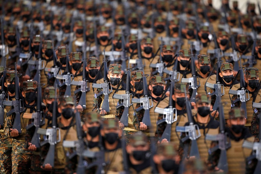 Dozens of masked soldiers stand in formation.