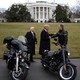 President Trump shakes hands with the Harley-Davidson CEO in front of motorcycles.