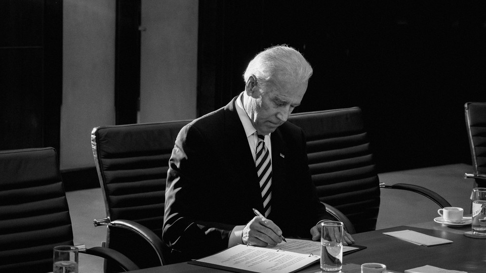 Biden signs a document.