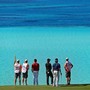 Professional golfers and their caddies study the view at a course in Bermuda.
