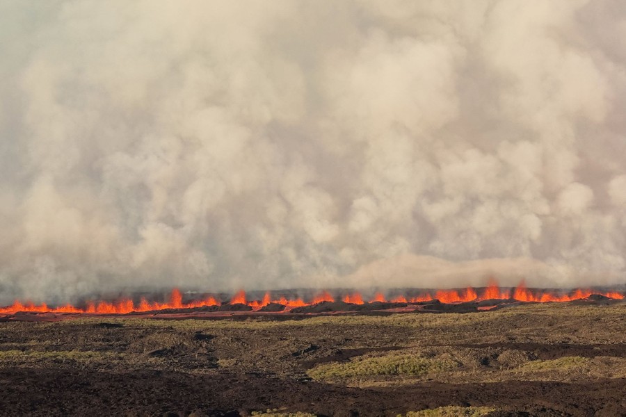 A line of erupting lava across a barren field
