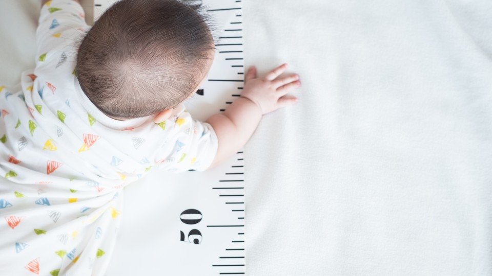 Baby crawling over growth measuring tape