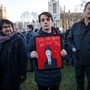 A protester holds a framed image of Labour leader Jeremy Corbyn and the words "For The Many Not The Jew."