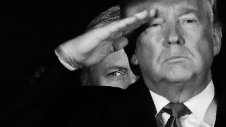 White House National Security Adviser Robert O’Brien stands behind President Donald Trump as he salutes.