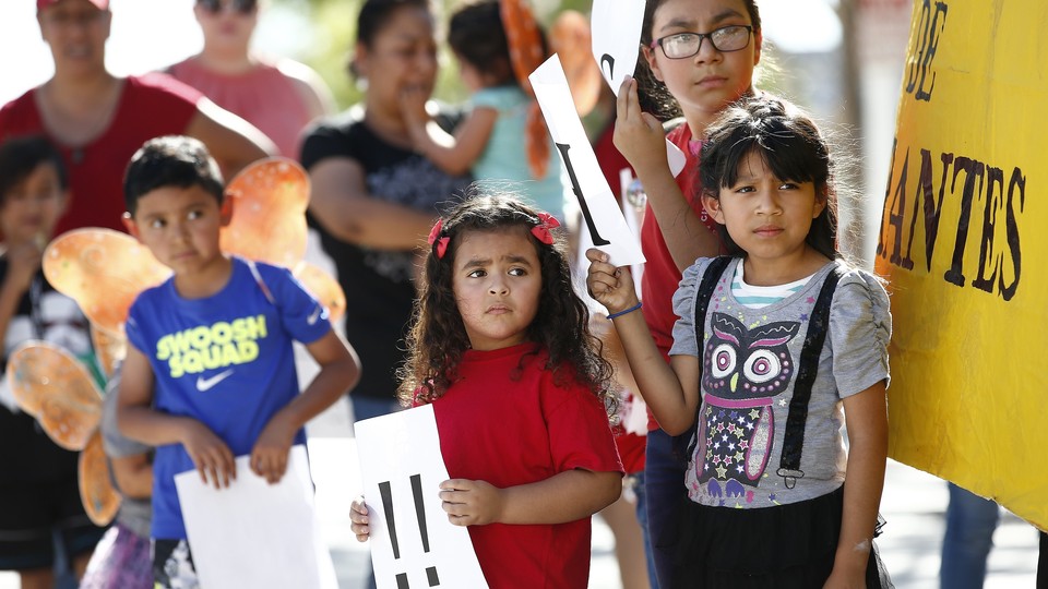 Children listen to speakers during an immigration family-separation protest on June 18, 2018, in Phoenix