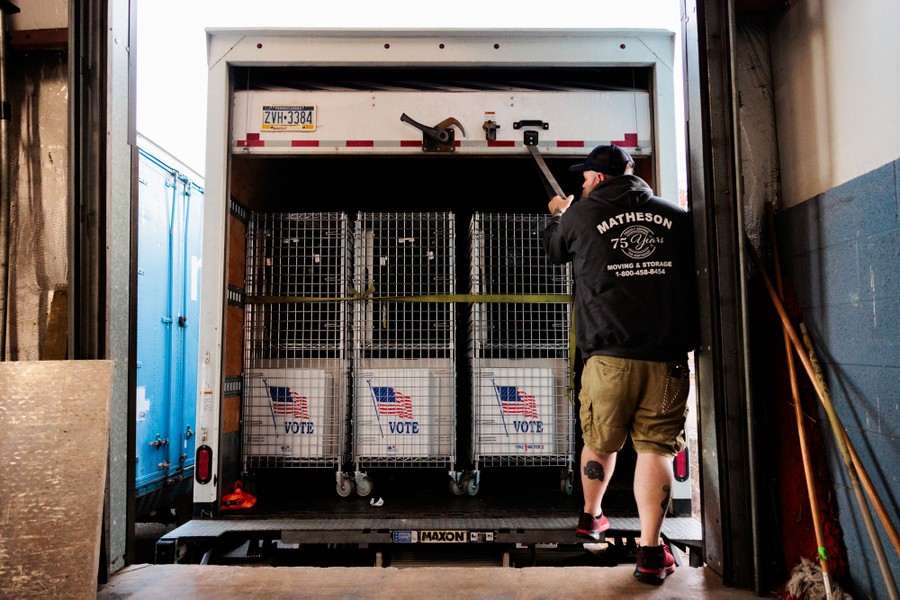 A worker closes a truck holding election equipment.