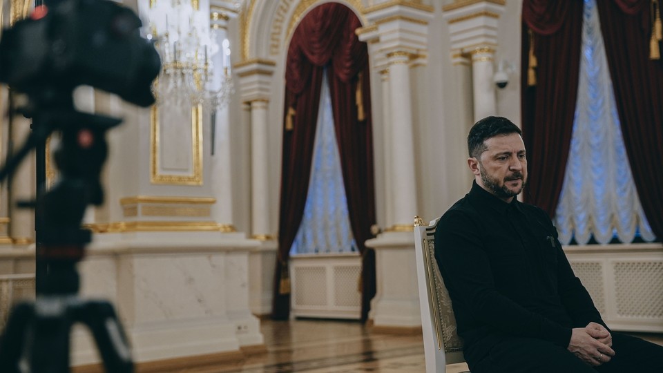 A color photograph of Zelensky seated and looking off camera during an interview