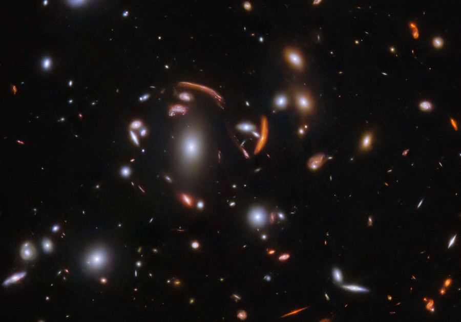 A view of dozens of galaxies, many of them distorted and smeared by gravitational lensing
