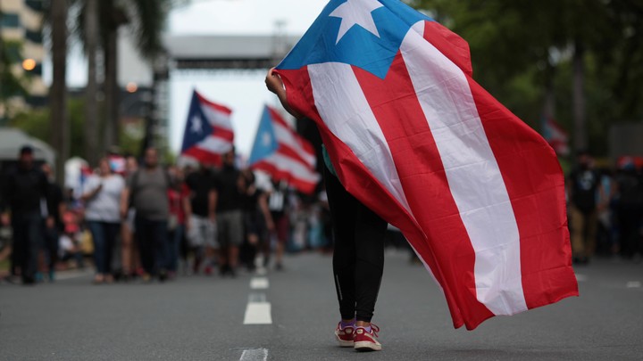 A Puerto Rican flag is waved during a protest against government austerity measures as the island faced a looming deadline to restructure its $70 billion debt in San Juan, Puerto Rico on May 1, 2017.