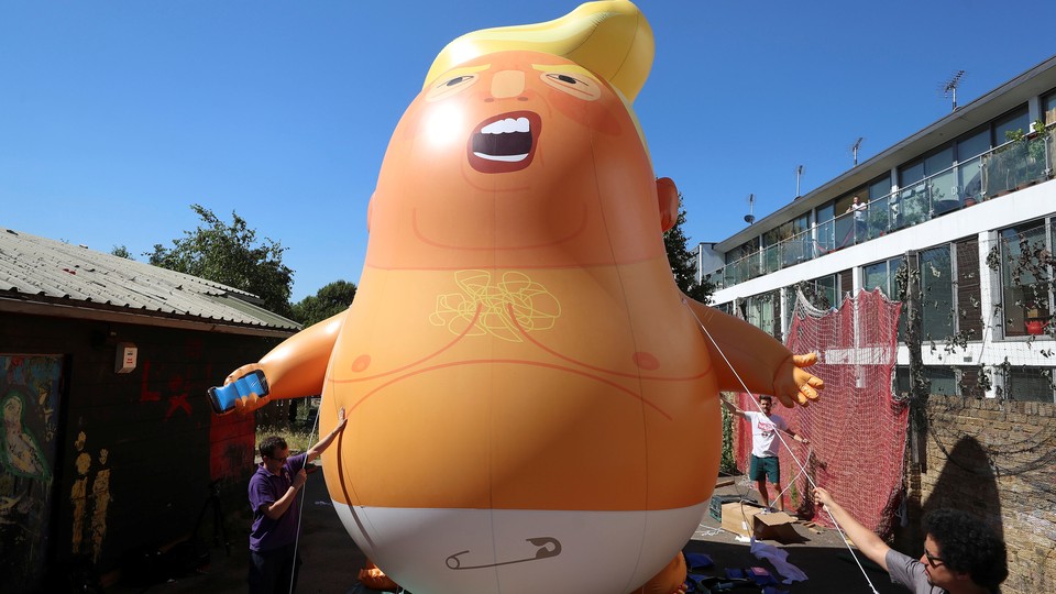 People inflate a Donald Trump blimp to be flown over London during the president's visit