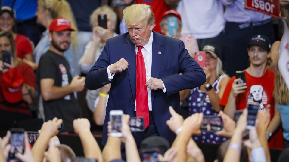 President Donald Trump gestures to the crowd before exiting a campaign rally.