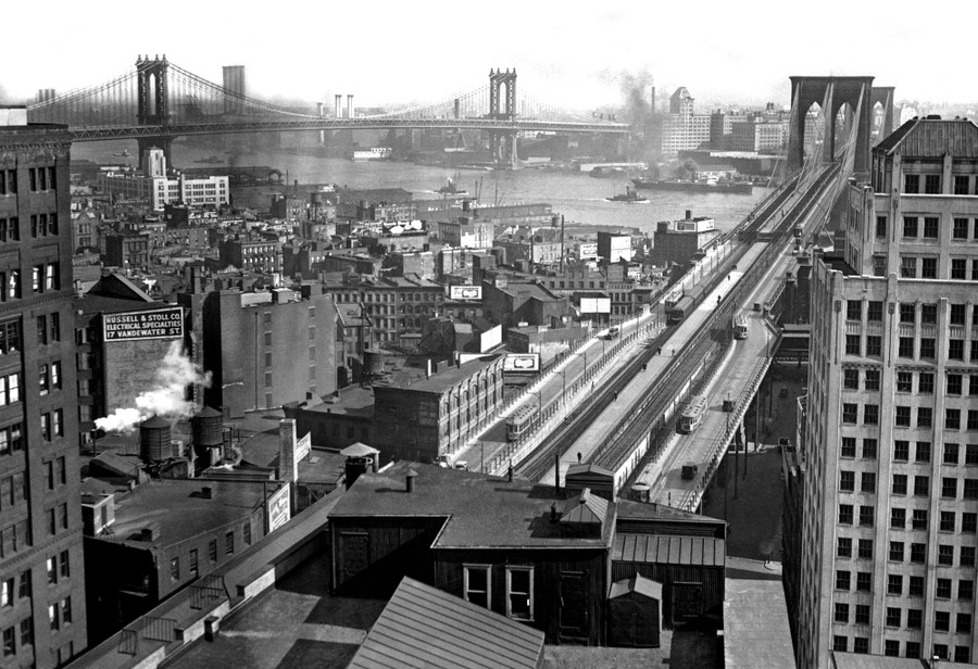 A view of a 1920s-era New York City neighborhood and two large bridges