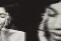 Photo illustration of a woman holding her head in her hands