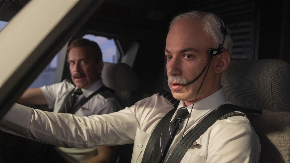 Nathan Fielder wears a white wig and fake mustache, posing as an airline pilot