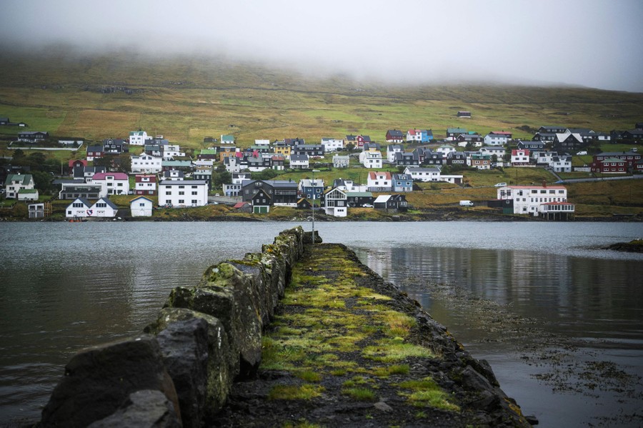 A small coastal village is seen from the water.