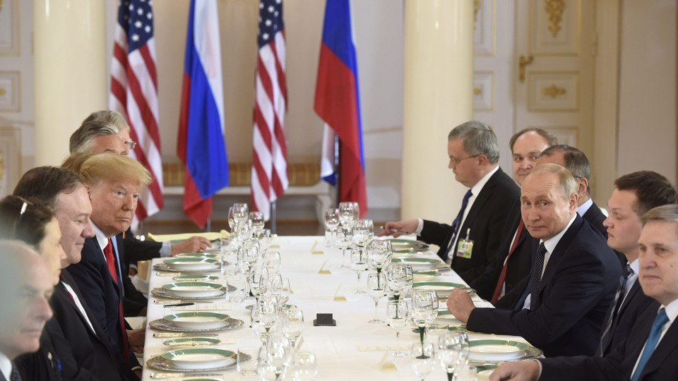 Trump and Putin are seated at a long table at a lunch meeting with other leaders and advisors.