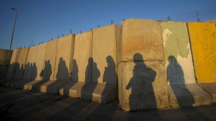 The shadows of Palestinian women at the Qalandiya checkpoint outside the West Bank city of Ramallah