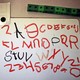 A whiteboard rests next to dry-erase markers and is covered in a student's attempts to scribble the alphabet.