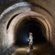 A worker examines brickwork in a London sewer.