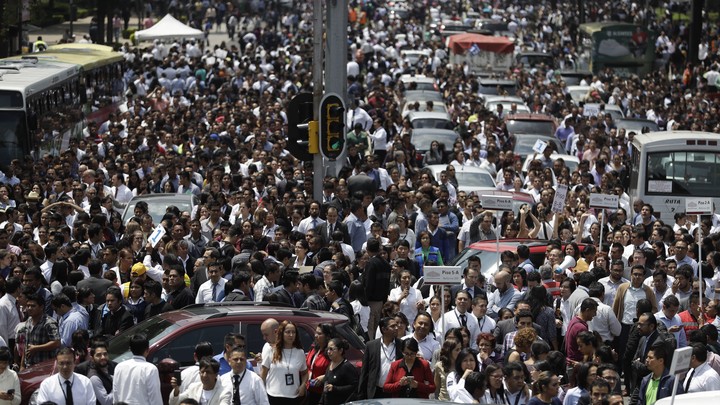 People evacuated from office buildings gather in Reforma Avenue