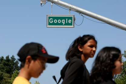 People walk past a street sign that reads "Google."