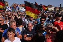 A photo of AfD supporters waving German flags at a rally ahead of the 2024 election.