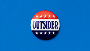 An illustration of a campaign button that says, 'Outsider'