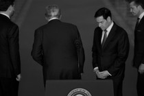 Donald Trump flanked by aides at a press conference