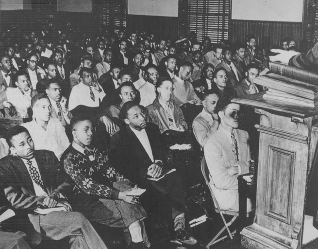 photo of MLK in front row of large audience at Morehouse College