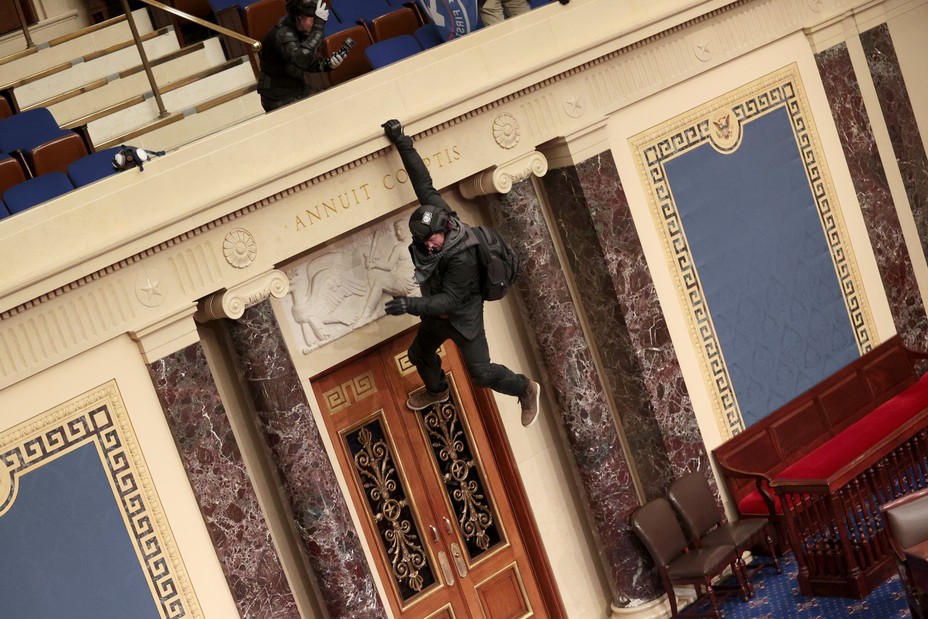 insurrectionist hangiing from balcony in capitol building