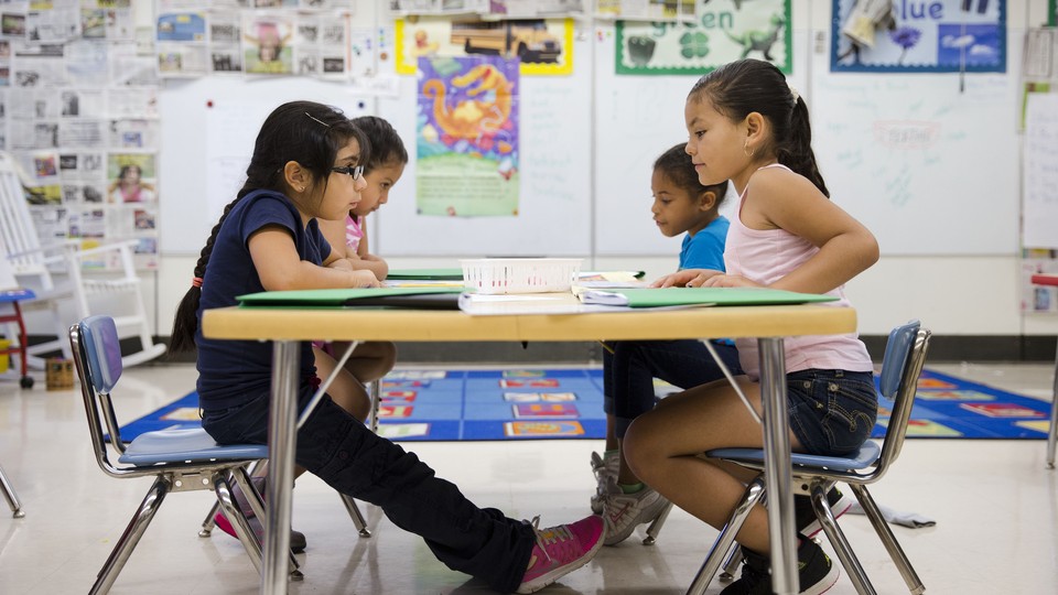 Hispanic kindergartners sit at a desk in a classroom in Kennett Square, Pennsylvania