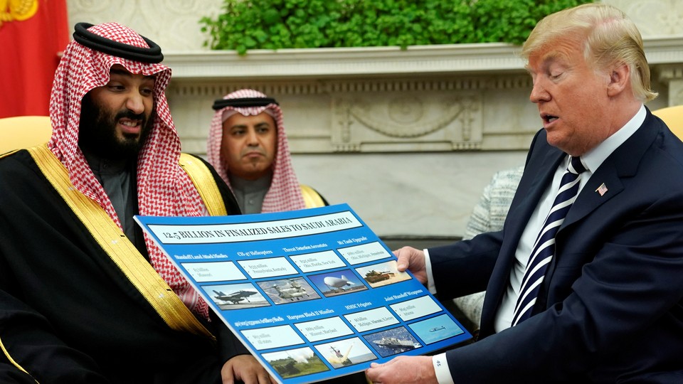 Donald Trump holds a chart of military hardware sales as he welcomes Saudi Arabia's Crown Prince Mohammed bin Salman in the Oval Office in May 2018