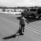 A man drags a dear carcass across a road to his car