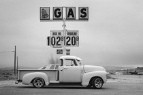 A truck parked in front of a gas sign.