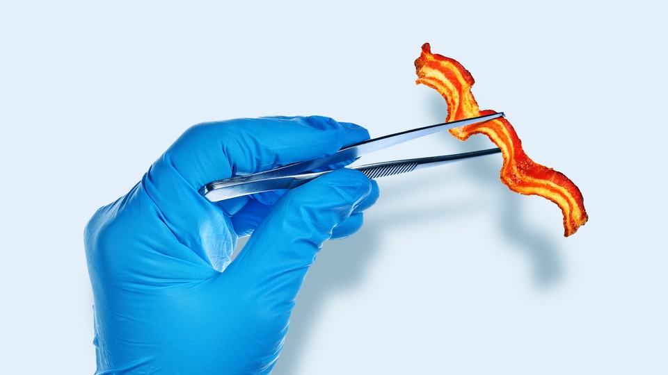 A piece of bacon between lab tweezers